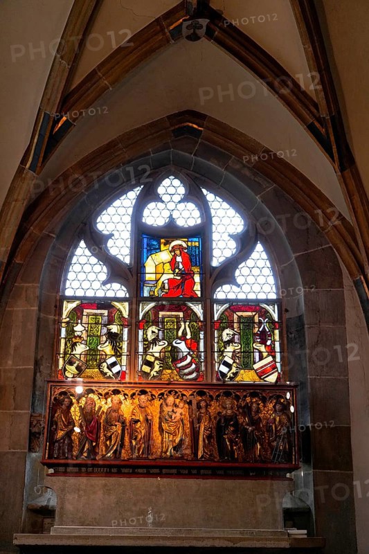 The interior of the largest Protestant church in Germany. It has the world's highest church tower, Ulm Minster, Germany, Europe, Colourful stained glass window with religious scenes in a Gothic setting, Ulm