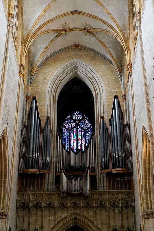 The interior of the largest Protestant church in Germany. It has the world's highest church tower, Ulm Minster, Germany, Europe, Large organ with pipes in front of a colourful window in a Gothic church, Ulm