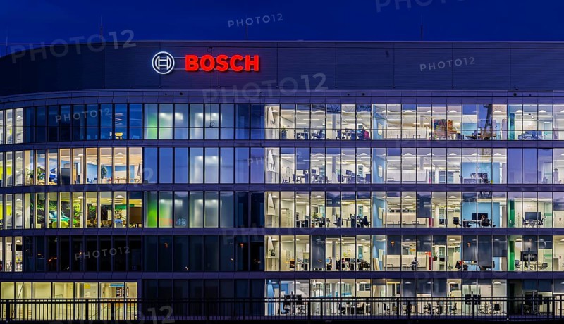 Modern office building of Bosch GmbH in Feuerbach at night with illuminated logo of the automotive supplier. Bosch Digital, Bosch IT Campus, Building 701, Stuttgart, Baden-Württemberg, Germany
