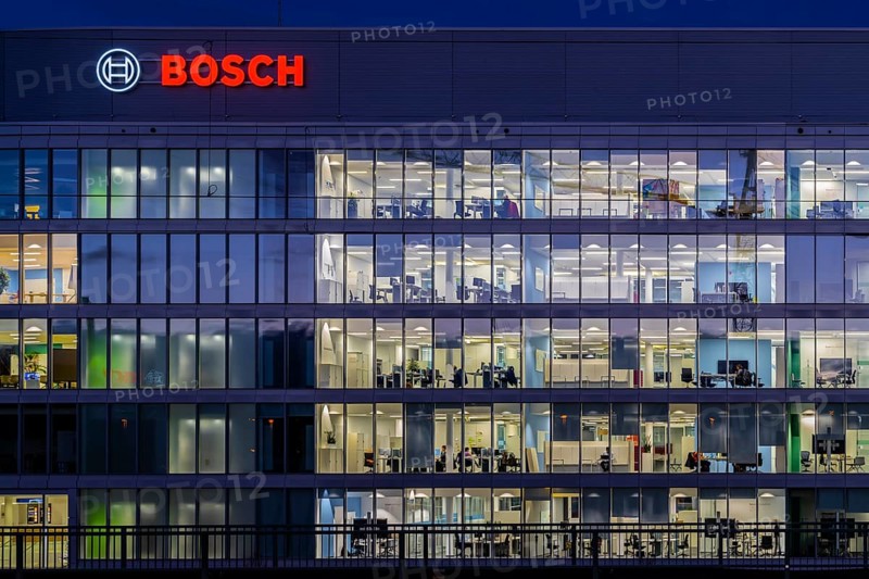 Modern office building of Bosch GmbH in Feuerbach at night with illuminated logo of the automotive supplier. Bosch Digital, Bosch IT Campus, Building 701, Stuttgart, Baden-Württemberg, Germany