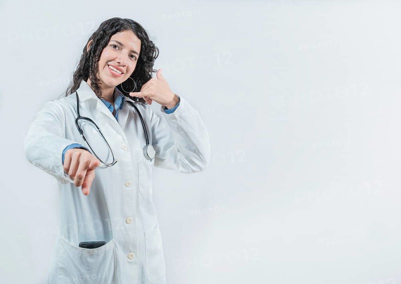 Beautiful female doctor gesturing call isolated. Woman doctor making call gesture and pointing at the camera