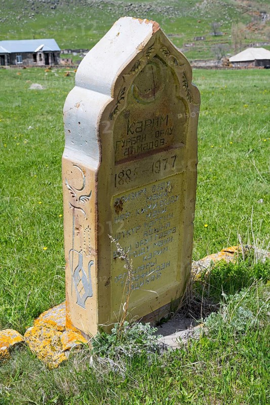Old gravestone on a green meadow in a rural setting in sunny weather, old cemetery, Aghvorik, Shirak province, Armenia