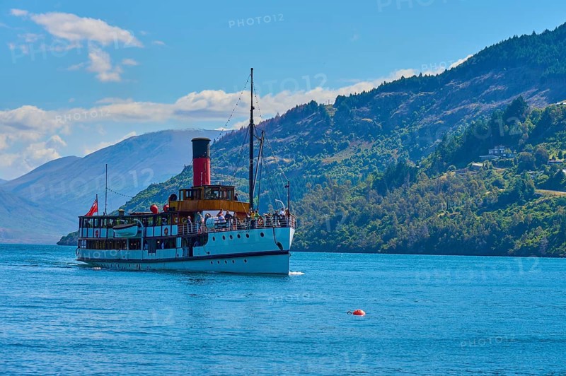 Large ship sailing across a wide lake with picturesque mountain ranges in the background, Queenstown, Queenstown-Lakes District, Otago, South Island, New Zealand