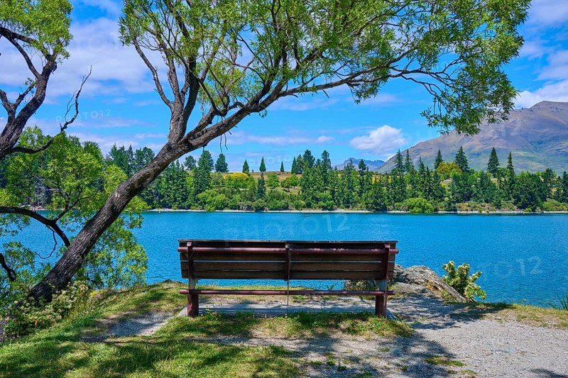Idyllic landscape with bench and view of a lake and mountains in the background, Queenstown, Queenstown-Lakes District, Otago, South Island, New Zealand