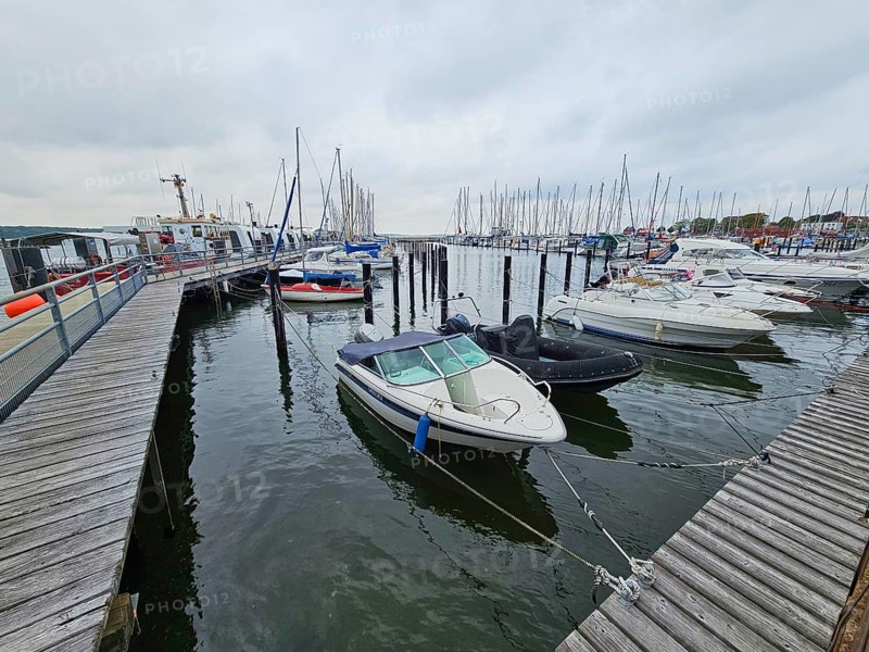 Several motorboats are moored in a harbour, surrounded by jetties and under an overcast sky, Laboe, Kiel Fjord, Schleswig-Holstein, Germany