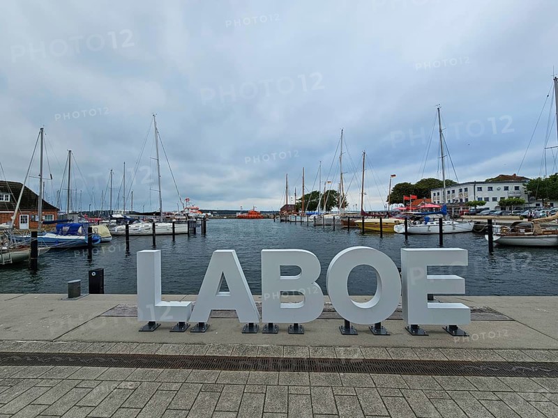 LABOE lettering at the edge of the harbour, surrounded by sailing boats and a cloudy sky, Laboe, Kiel Fjord, Schleswig-Holstein, Germany
