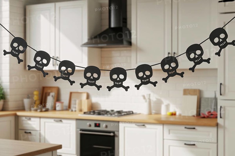 Black skull and crossbones Halloween garland hanging in cozy kitchen interior. Generative AI, AI generated