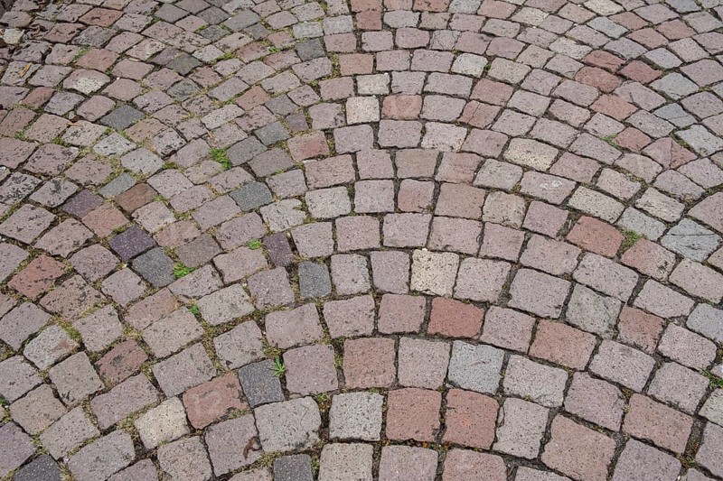 Floor covering made of paving stones with an arched pattern in grey and reddish tones, background, texture, Germany