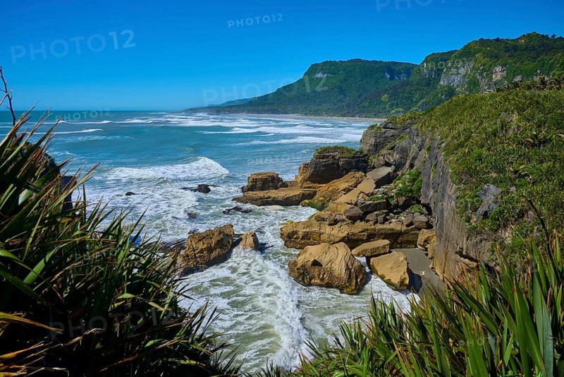Rocky coast with stormy surf and dense vegetation, Pancake Rocks, Westport, Greymouth, West Coast, South Island, New Zealand