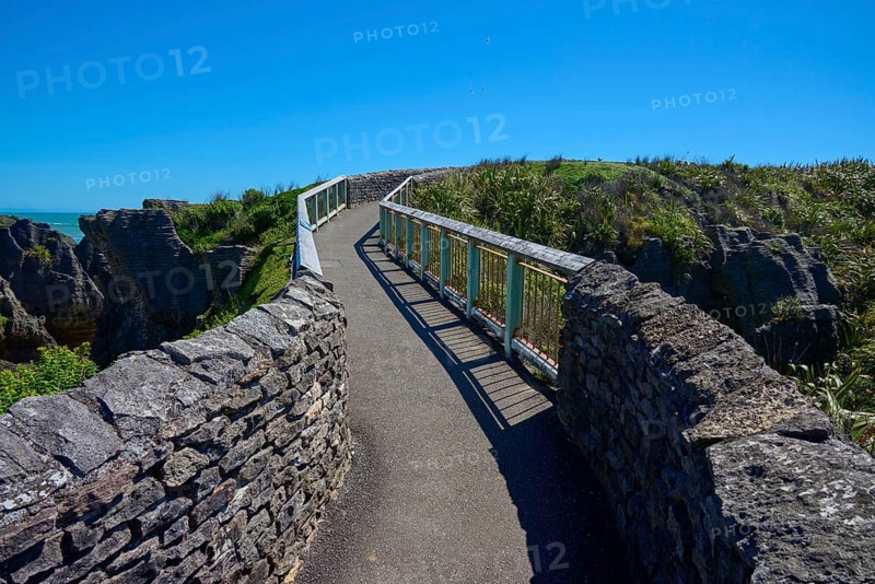 A stone path leads along the cliffs with a picturesque view of the sea, Pancake Rocks, Westport, Greymouth, West Coast, South Island, New Zealand