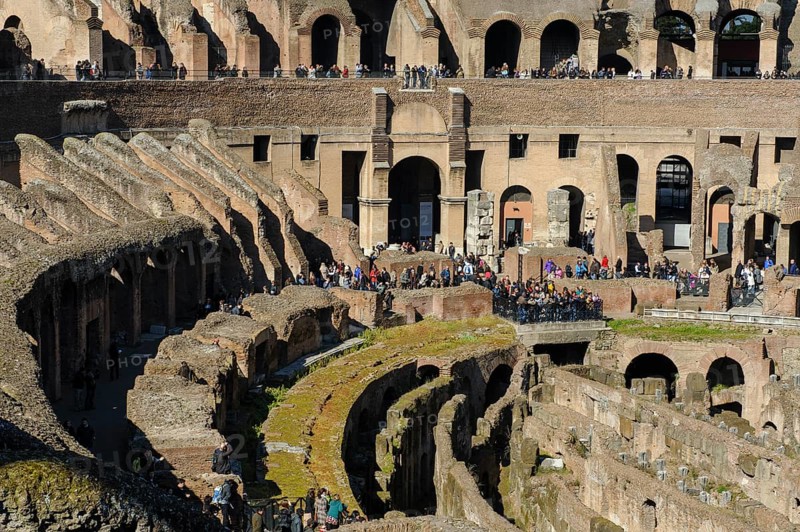View of hypogeum from the time of Emperor Domitian exposed at the bottom front, in the centre of the picture behind it ancient west gate of Colosseum Amphitheatrum Flavium so-called Tor tor of Death Porta della Morte for the removal of killed gladiators, Rome, Latium, Italy