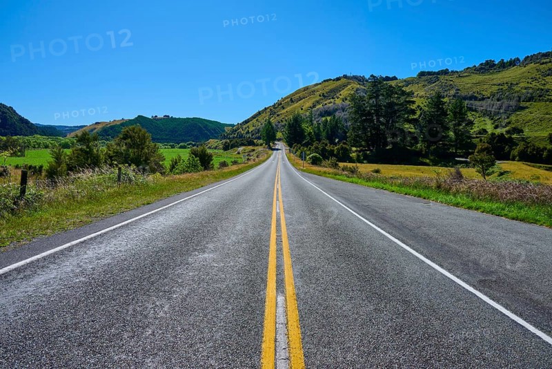 Straight country road with green hills and blue sky, peaceful natural scenery, Buller River, Murchison, Tasman, South Island, New Zealand