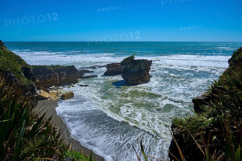 Breathtaking coastal landscape with rocks in the sea under a bright blue sky, Pancake Rocks, Westport, Greymouth, West Coast, South Island, New Zealand