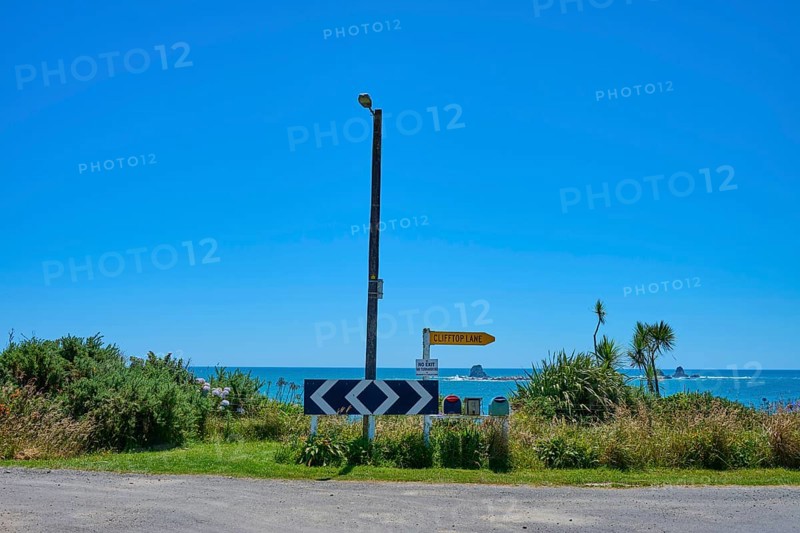 View of a coastline with road signs and blue sky, Cape Foulwind, West Coast, South Island, New Zealand