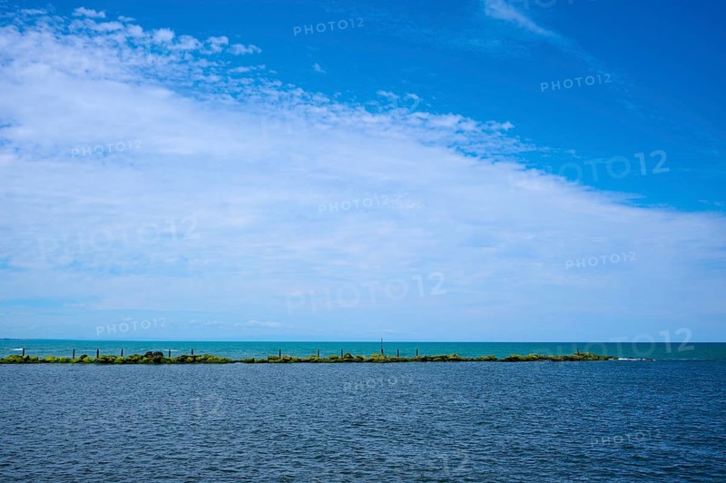 Sweeping view of the calm sea under a partly cloudy blue sky, Mana Bay, Patea, Taranaki, North Island, New Zealand