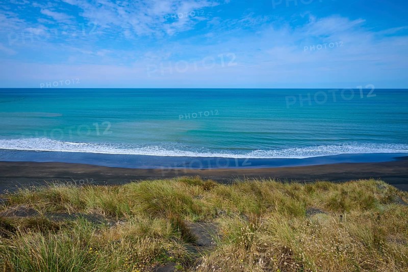Panoramic view of the endless sea with grassy coastline and gentle waves under a clear sky, Mana Bay, Riverview Lookout, Patea, Taranaki, North Island, New Zealand