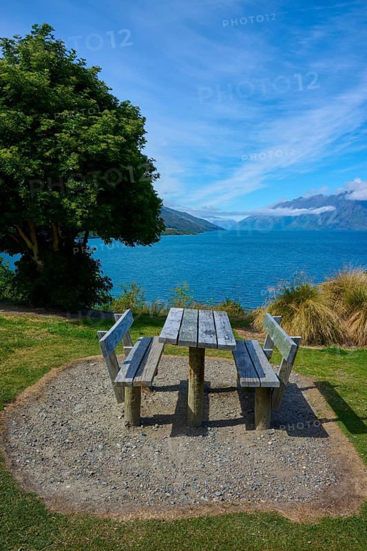 Single picnic table overlooking lake and mountains in scenic setting, Drift Bay, Lake Wakatipu, Queenstown-Lakes District, Otago, South Island, New Zealand