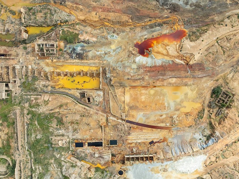 Old mining site and deep orange-red hues in the water of a pool in the mineral-rich area of the Rio Tinto mines. The colour is caused by oxidised iron minerals. Aerial view. Drone shot. Huelva province, Andalusia, Spain