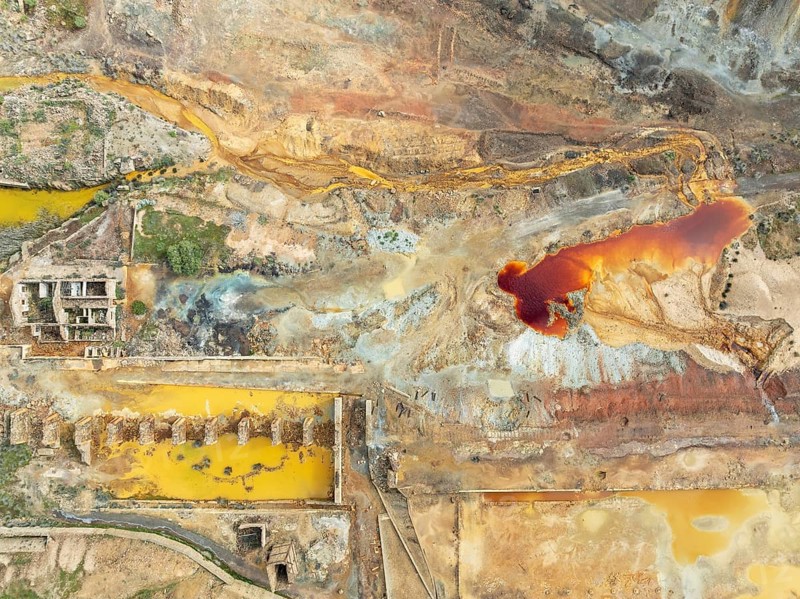 Old mining site and deep orange-red hues in the water of a pool in the mineral-rich area of the Rio Tinto mines. The colour is caused by oxidised iron minerals. Aerial view. Drone shot. Huelva province, Andalusia, Spain