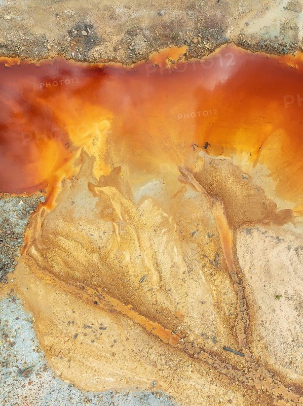 Deep orange-red hues in the water of a pool in the mineral-rich area of the Rio Tinto mines. The colour is caused by oxidised iron minerals. Aerial view. Drone shot. Huelva province, Andalusia, Spain