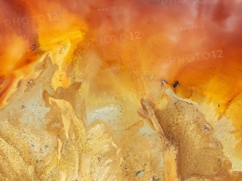Abstract patterns in a pool in the mineral-rich area of the Rio Tinto mines. The colour is caused by oxidised iron minerals. Aerial view. Drone shot. Huelva province, Andalusia, Spain