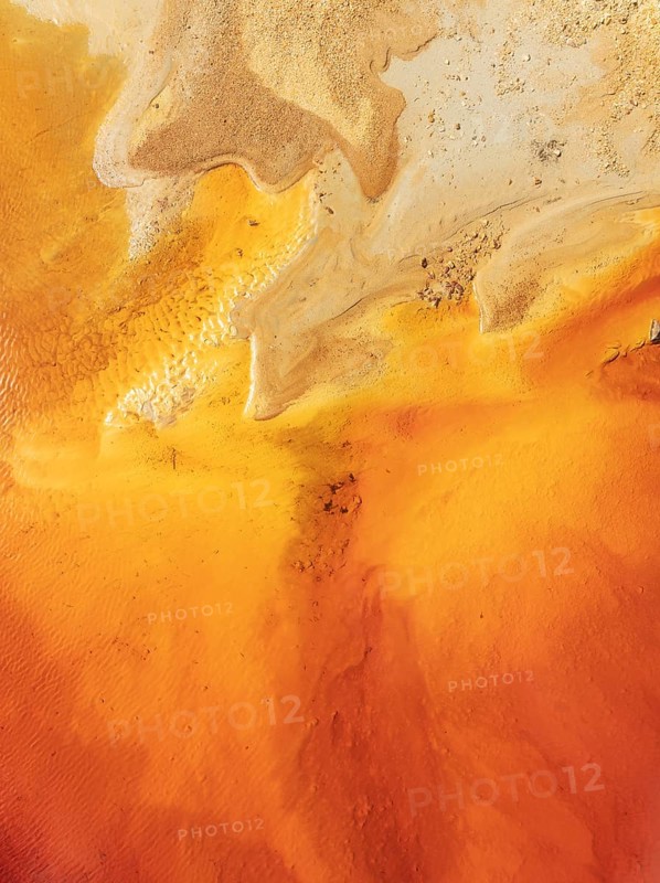 Abstract patterns in a pool in the mineral-rich area of the Rio Tinto mines. The colour is caused by oxidised iron minerals. Aerial view. Drone shot. Huelva province, Andalusia, Spain