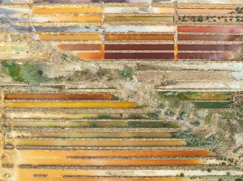Abandoned saline ponds in the mineral-rich area of the Rio Tinto mines, hence the different colours caused by oxidised iron minerals. Aerial view. Drone shot. Huelva province, Andalusia, Spain