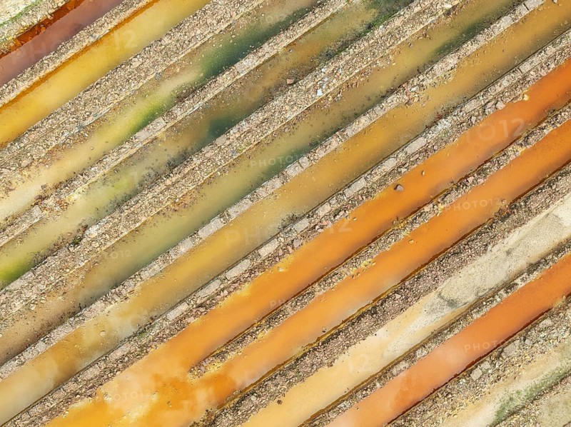 Abandoned saline ponds in the mineral-rich area of the Rio Tinto mines, hence the different colours caused by oxidised iron minerals. Aerial view. Drone shot. Huelva province, Andalusia, Spain