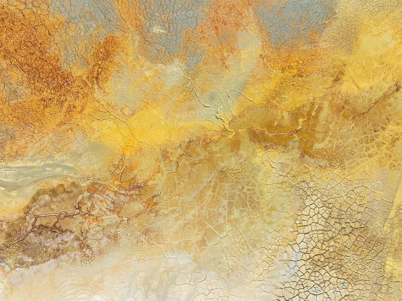 Abstract patterns in a waste pond in the mineral-rich area of the Rio Tinto mines. The colour is caused by oxidised iron minerals. Aerial view. Drone shot. Huelva province, Andalusia, Spain