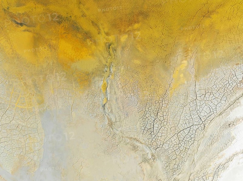 Abstract patterns in a waste pond in the mineral-rich area of the Rio Tinto mines. The colour is caused by oxidised iron minerals. Aerial view. Drone shot. Huelva province, Andalusia, Spain