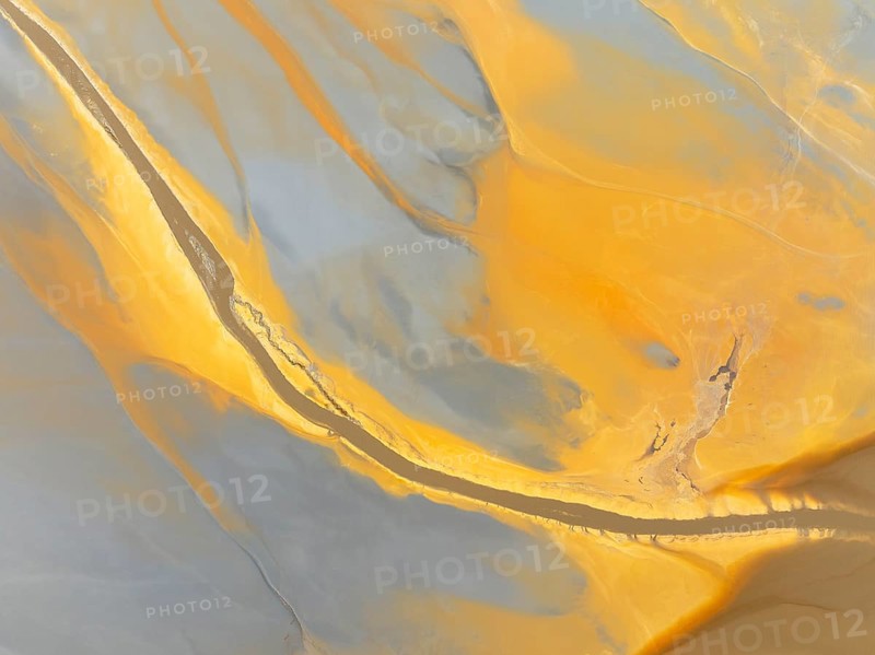 Abstract patterns in a waste pond in the mineral-rich area of the Rio Tinto mines. The colour is caused by oxidised iron minerals. Aerial view. Drone shot. Huelva province, Andalusia, Spain