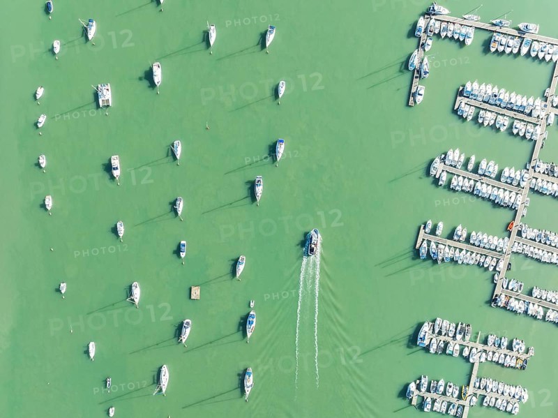 Sports and fishing boats at the marina of the fishing village of Sancti Petri. In the marshland of the Bahía de Cádiz Nature Reserve. Aerial view.. Drone shot. Cádiz province, Andalusia, Spain