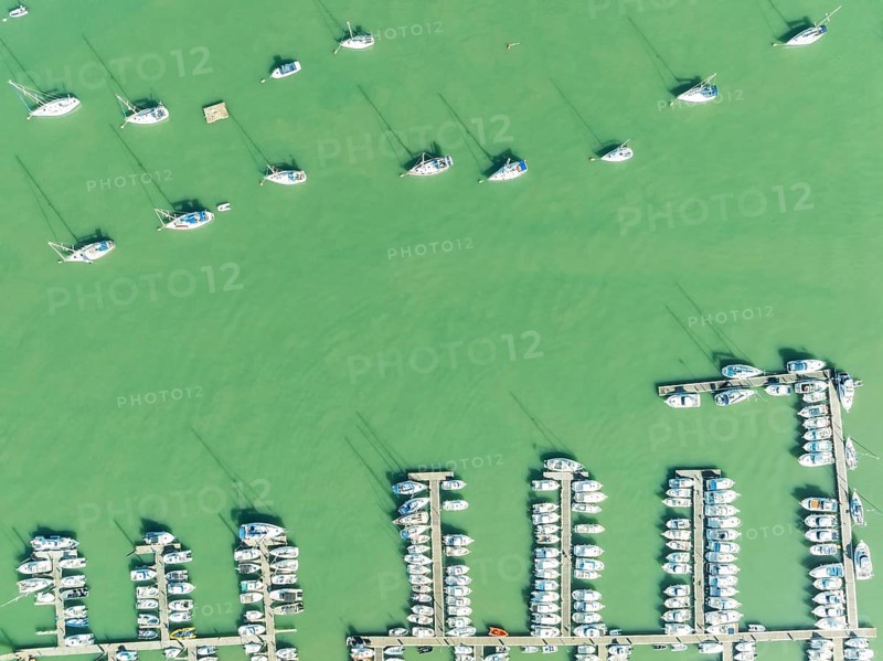 Sports and fishing boats at the marina of the fishing village of Sancti Petri. In the marshland of the Bahía de Cádiz Nature Reserve. Aerial view.. Drone shot. Cádiz province, Andalusia, Spain