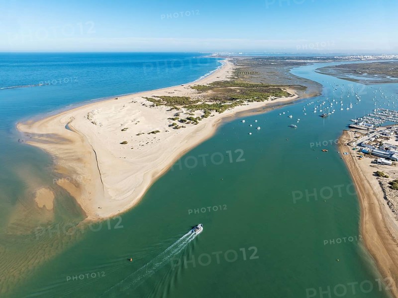 The large sandbar of Punta del Boquerón and partial view of the fishing village of Sancti Petri. In the distance top right the town of San Fernando. Aerial view. Drone shot. Bahía de Cádiz Nature Reserve. Cádiz province, Andalusia, Spain