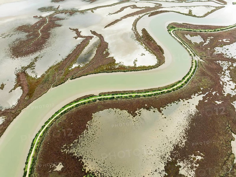The Barbate river and surrounding marshland at low tide. Nature Reserve La Breña y Marismas del Barbate. Aerial view. Drone shot. Cádiz province, Andalusia, Spain