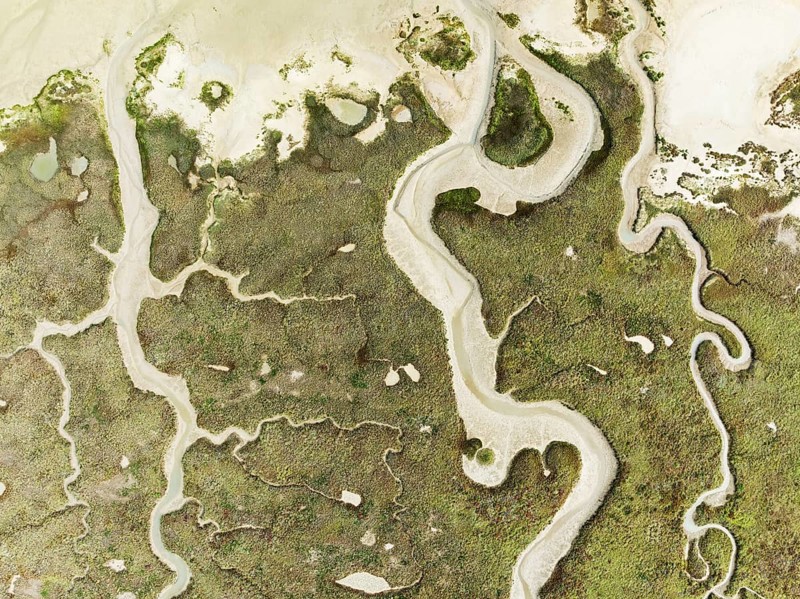 Abstract patterns of dry streams at low tide. In the marshland of the Bahía de Cádiz Nature Reserve. Aerial view. Drone shot. Cádiz province, Andalusia, Spain