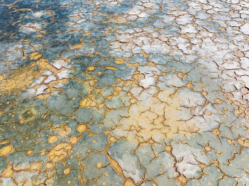 Abstract patterns in the shallow water of a saline pond in the marshland of the Bahía de Cádiz Nature Reserve. Aerial view. Drone shot. Cádiz province, Andalusia, Spain
