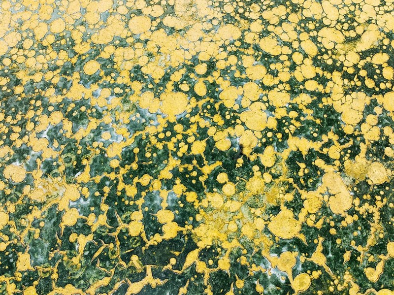 Abstract patterns in the shallow water of a saline pond in the marshland of the Bahía de Cádiz Nature Reserve. Aerial view. Drone shot. Cádiz province, Andalusia, Spain