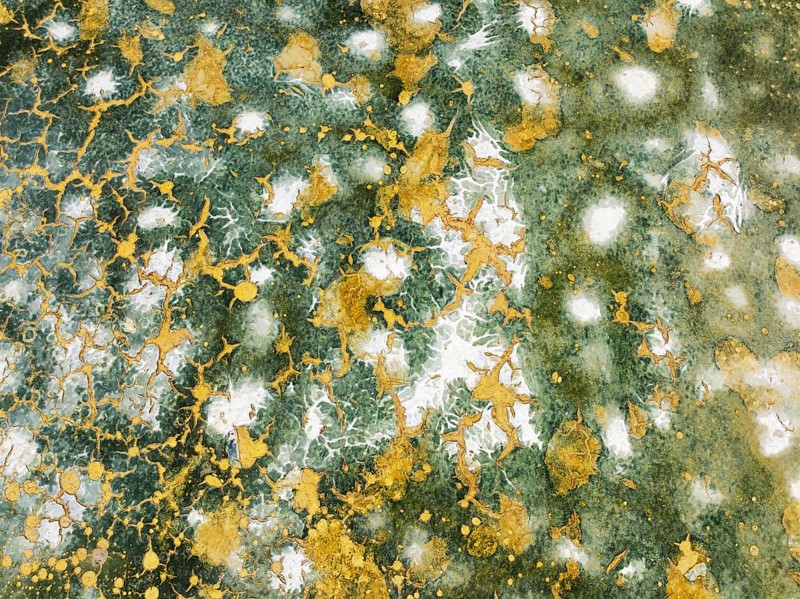 Abstract patterns in the shallow water of a saline pond in the marshland of the Bahía de Cádiz Nature Reserve. Aerial view. Drone shot. Cádiz province, Andalusia, Spain