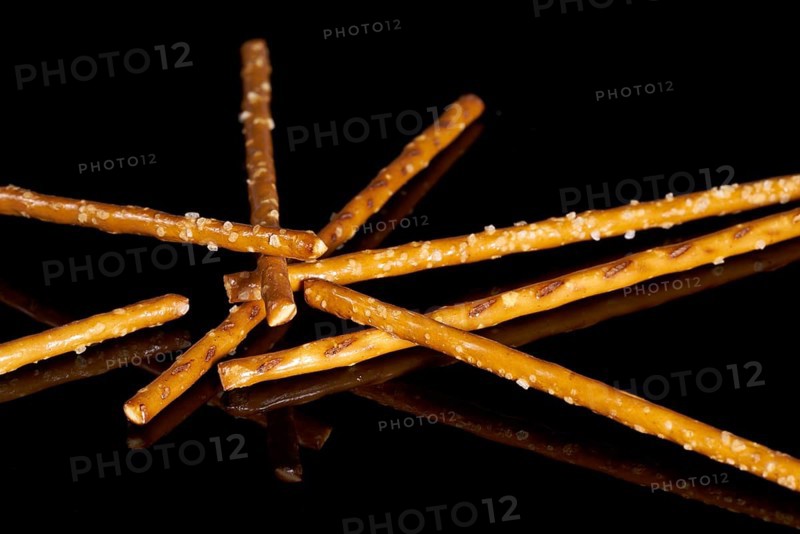 Closeup of some salt sticks on dark striped glossy ground