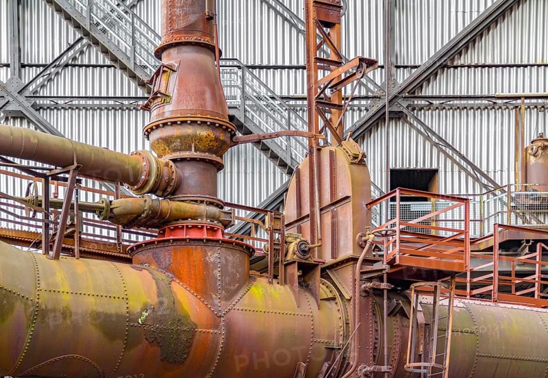 Weathered rusty high angle industrial scenery with old corroded steel girders and metal tubes