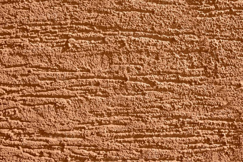 Full frame background showing brown rough plaster