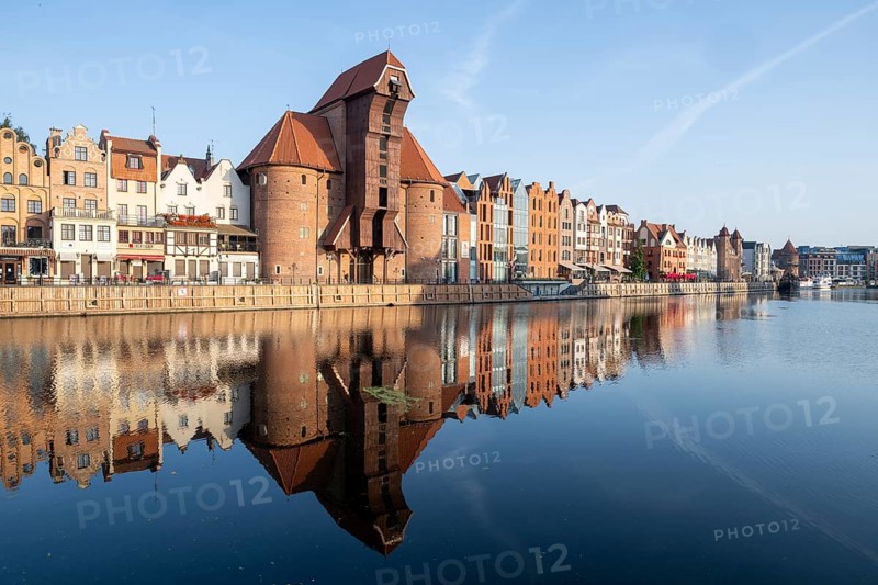 Waterfront promenade with reflection at sunrise in the Old Town, Motlawa River, Gdansk, Poland