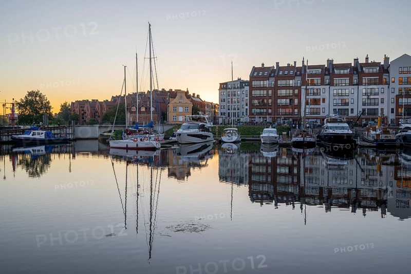 Waterfront promenade with reflection at sunrise in the old town, Motlawa river, boat harbour, Gdansk, Gdansk, Poland