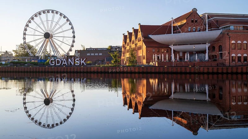 Ferris wheel on the waterfront with reflection at sunrise in the old town, Motlawa River, Gdansk, Gdansk, Poland
