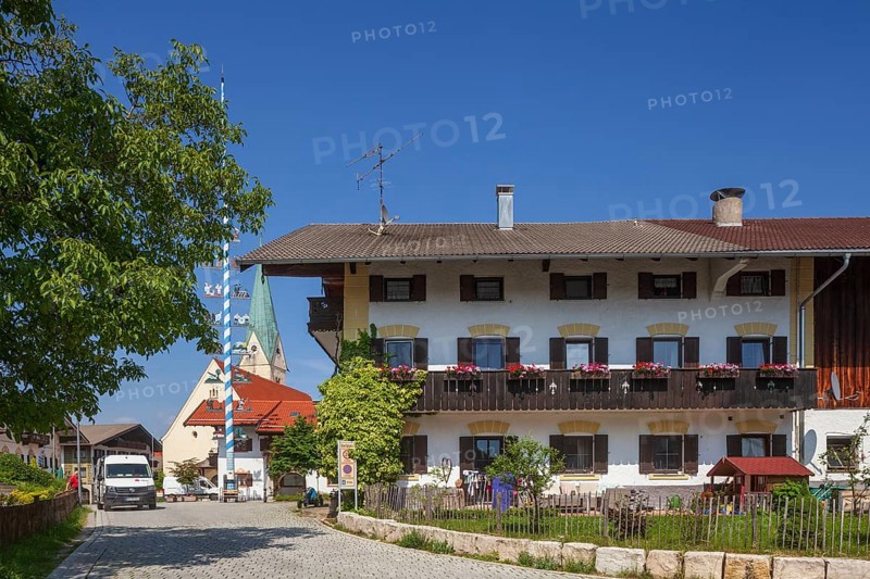 Parish Church of the Assumption of the Virgin Mary with maypole and old houses on the village square, Törwang, Samerberg, Chiemgau, Upper Bavaria, Bavaria, Germany