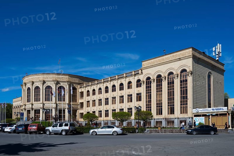 Large historic building in the city centre under a blue sky with parked cars, Gyumri, Gyumri, Gyumri, Shirak Province, Armenia