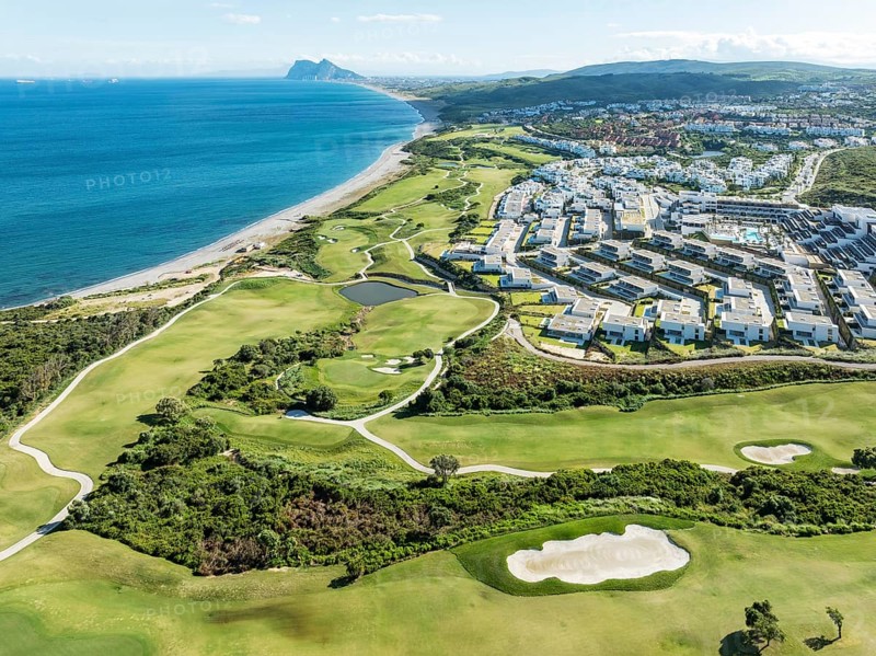 The La Hacienda Links Golf Resort at the Mediterranean Sea with the Rock of Gibraltar (British) in the distance. Prominent the Fairmont La Hacienda hotel. Aerial view. Drone shot. Cádiz province, Andalusia, Spain