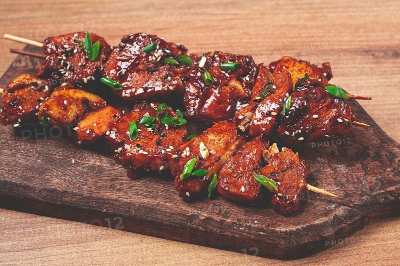 Yakitori chicken kebab, on skewers, with green onions and sesame seeds, top view, without people