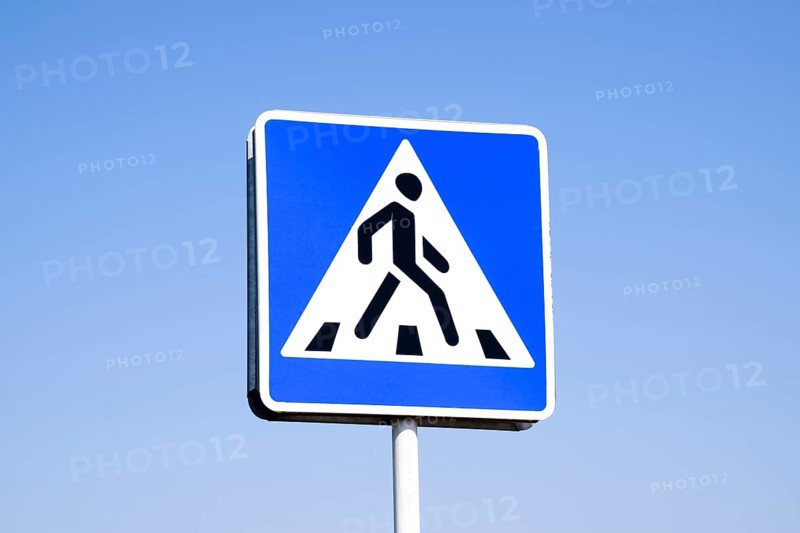 A pedestrian crossing sign. Sign on a blue sky background. Krasnodar, Russia